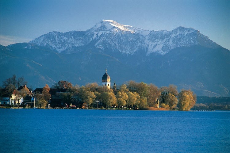 Die Fraueninsel mit dem Kloster Frauenchiemsee vor dem Chiemsee und dem Bergpanorama der Alpen